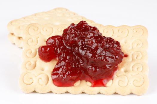 Close-up of some biscuits with jam, over white background. Selective focus.