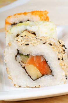 Close-up of some assorted sushi rolls on a white plate. Selective focus.