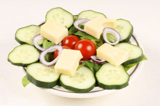 Close-up of a fresh mixed salad with cheese served on a dish.