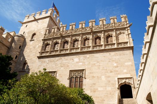 Lonja de la Seda of Valencia in Spain and the valencian flag. View from the garden. This small complex of late gothic buildings, originally was used to trade silk.