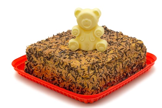 Delicious cake , decorated with the figure of a bear white chocolate. Presented on a white background.