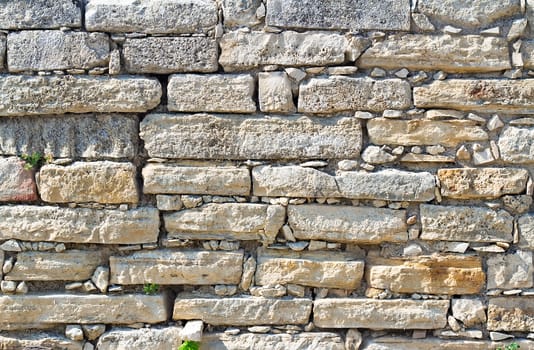 Fragment of the ancient stone wall executed from stones of various form and the size. Background image.