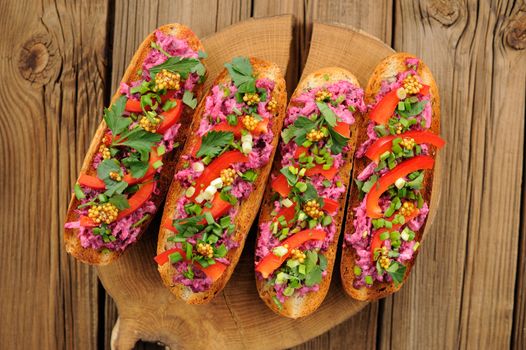 Vegetarian sandwiches with beetroot, bell pepper, parsley and scallion on wooden background horizontal