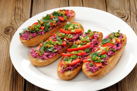 Vegetarian sandwiches with beetroot, bell pepper, parsley and scallion on white plate horizontal