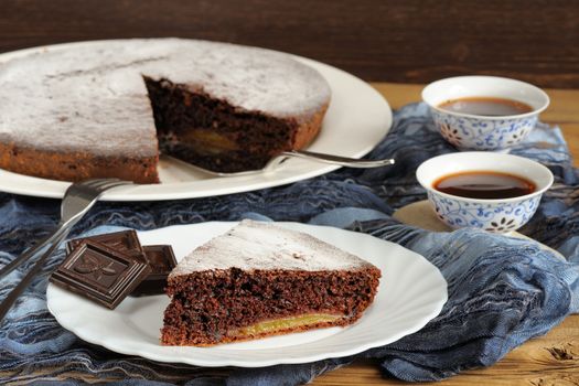 Chocolate cake and black tea on blue cloth horizontal