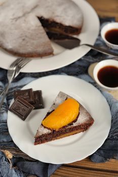 Chocolate cake with mango and black tea on blue cloth vertical
