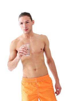 Portrait of a handsome shirtless man who is drinking water over a white background