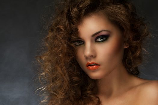 Beautiful caucasian woman with curls and evening makeup