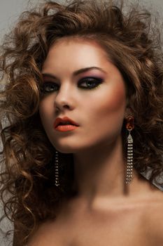 Beautiful caucasian woman with curls and evening makeup