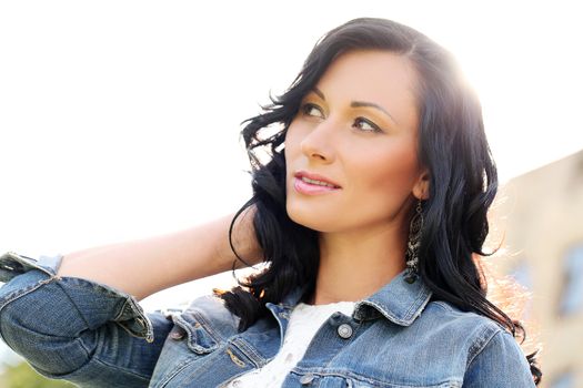 Beautiful young woman with jeans jacket in a park