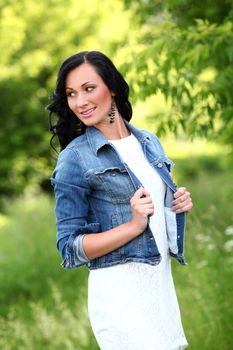 Beautiful young woman with jeans jacket in a park