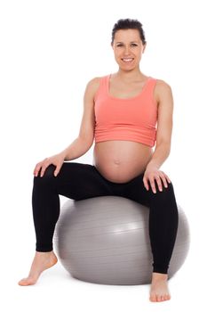 Beautiful pregnant woman sitting on a ball isolated over white background