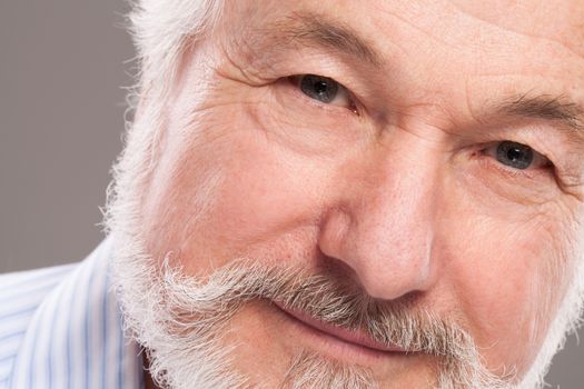 Handsome elderly man with grey beard over background