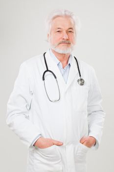 Handsome elderly doctor in uniform isolated over light background