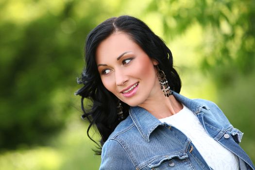 Beautiful young woman with jeans jacket in a park