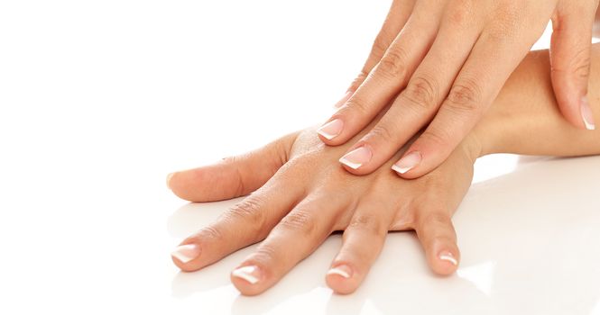 Young woman hands with french manicure over white background