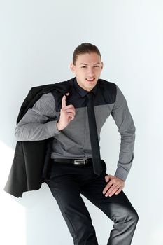 Portrait of a handsome man in a black suit who is posing over a white background