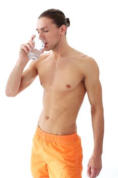 Portrait of a handsome shirtless man who is drinking water over a white background