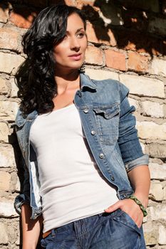 Beautiful young caucasian woman at the brick wall