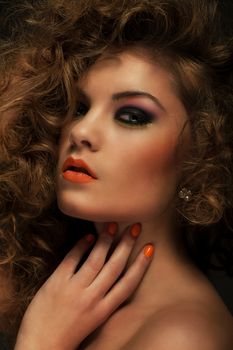 Beautiful caucasian woman with curls and evening makeup