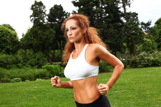 Beautiful middleaged caucasian woman working out in a park