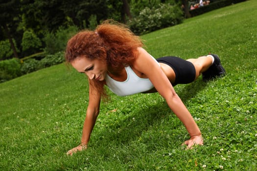 Beautiful middleaged caucasian woman working out in a park