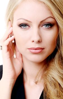 Portrait of a beautiful girl with blonde and curly hair who is posing over a white background