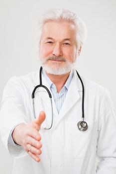 Handsome elderly doctor in uniform isolated over light background