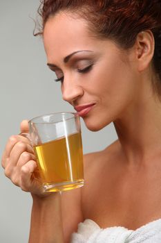 Beautiful middleaged woman in towel with herbal tea