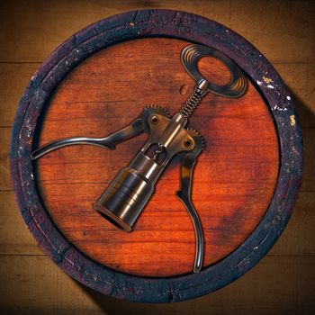 Old wooden barrel with a corkscrew on the background of wooden boards