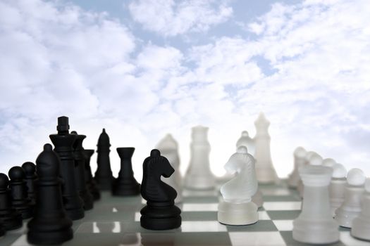 chess pieces isolated against a cloudy blue sky background