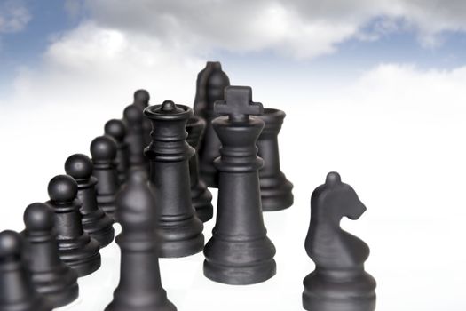 chess pieces isolated against a cloudy blue sky background