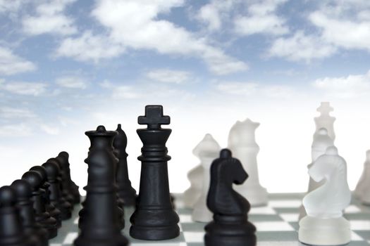 chess pieces isolated against a cloudy blue sky background