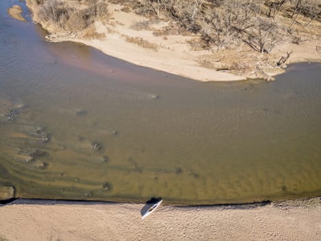 aerial view of South Platte River in eastern Colorado below Platteville with a canoe on sandbar, a typical winter scenery with a low flow