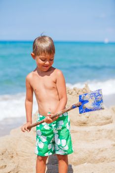 Young boy playing in the sand on the beach