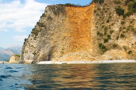 The rocks over the transparent ocean water. Montenegro. Rafailovici