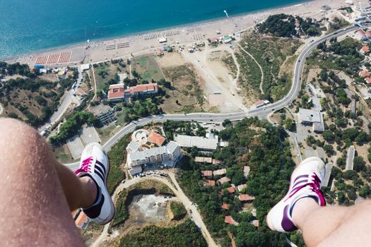 Hanging human feet over the Rafailovici, first person point of view Rafailovici, Montenegro