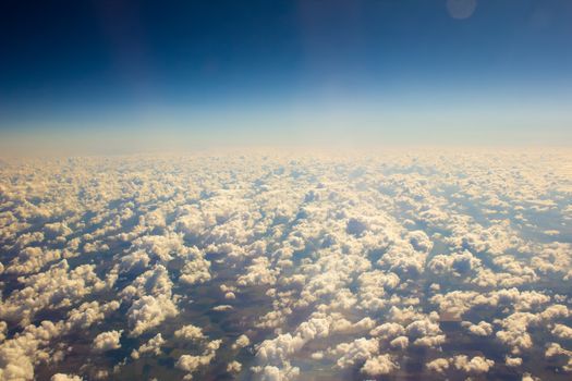 White clouds in a blue sky. Aerial view from airplane.