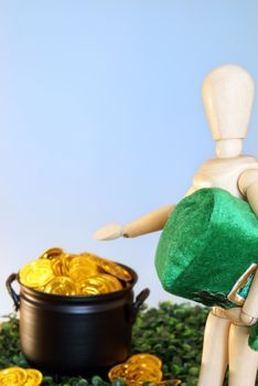 A wooden mannequin directs the viewer to a pot of gold.