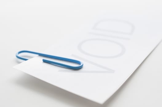 Void paper with blue paper clip on white background