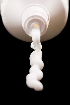 White tube from which the cream on a black background