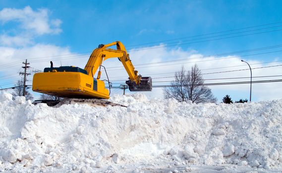 Excavator clearing snow in a parking lot