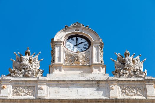 City antique clock with two statues on the sides