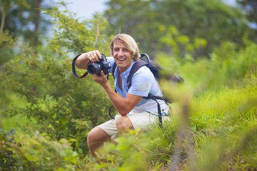 Photographer with Professional Digital Camera Taking Pictures in Nature