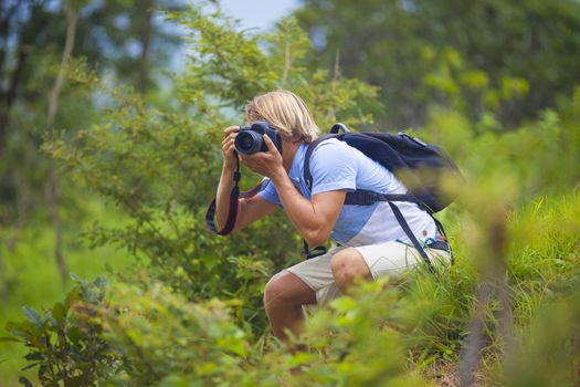 Photographer with Professional Digital Camera Taking Pictures in Nature