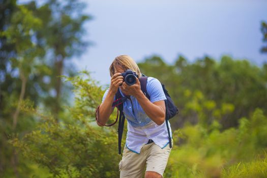 Photographer with Professional Digital Camera Taking Pictures in Nature