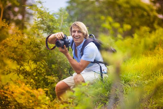 Photographer with Professional Digital Camera Taking Pictures in Nature