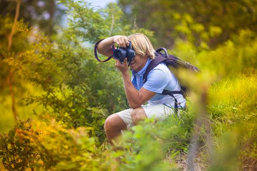 Photographer with Professional Digital Camera Taking Pictures in Nature