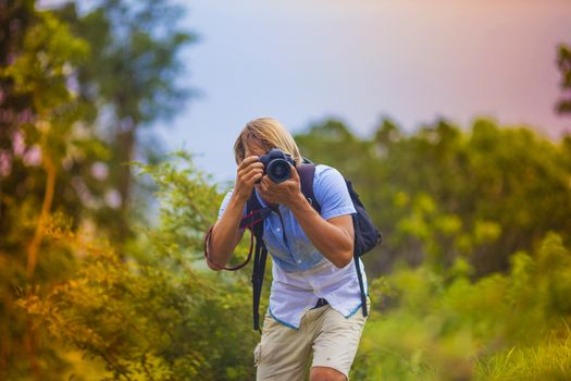 Photographer with Professional Digital Camera Taking Pictures in Nature