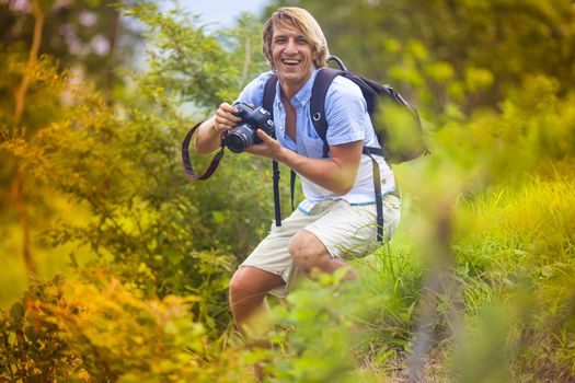 Photographer with Professional Digital Camera Taking Pictures in Nature